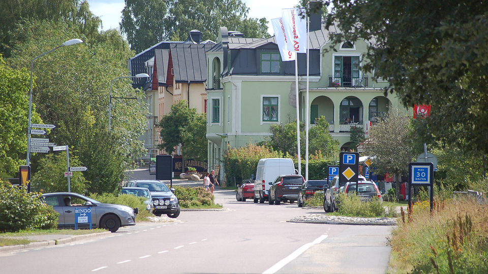 Storgatan i Bergsjö, bilar, parkeringsplatser och hus i bakgrunden.