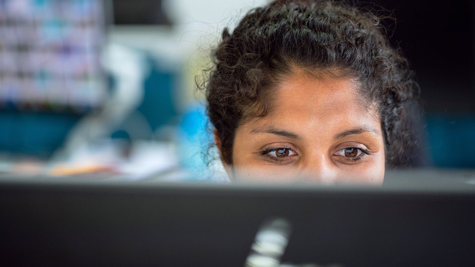 En kvinna tittar in i en datorskärm.