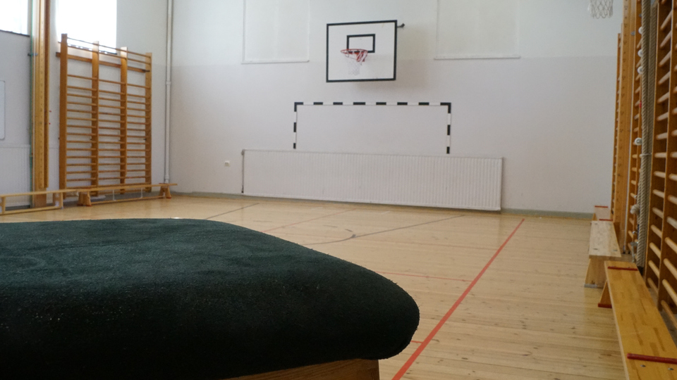 Idrottssal med en plint i förgrunden, ribbstolar och två basketkorgar, Arthur Engbergsskolan, Hassela