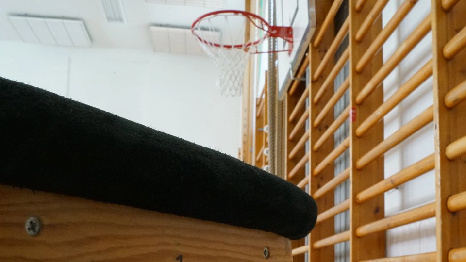 Ribbstolar och basketkorg i gymnastiksal