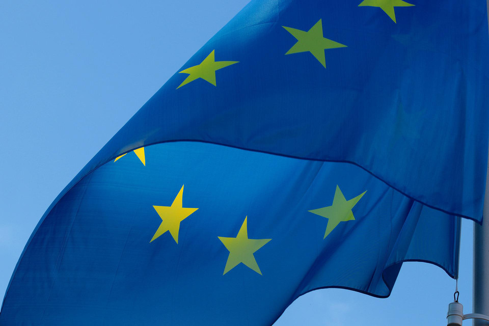 Bilden visar flaggan för EU mot en blå himmel.