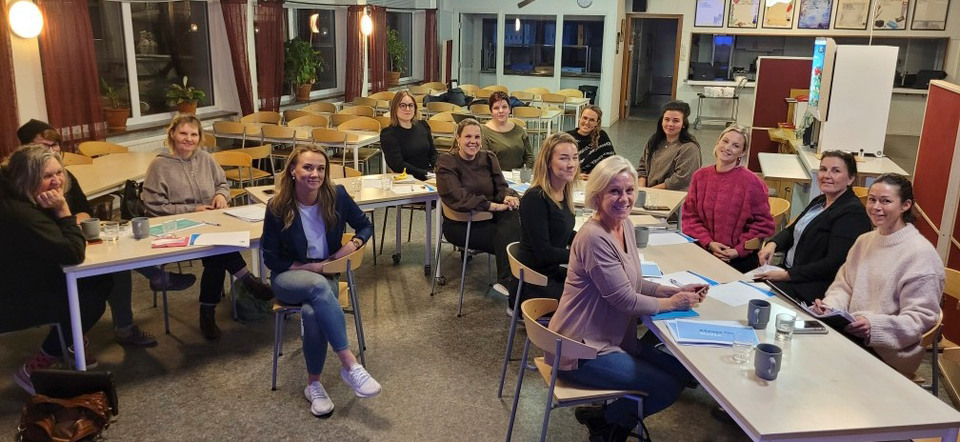 En grupp kvinnor har samlats i en skolsal för gemensam workshop.