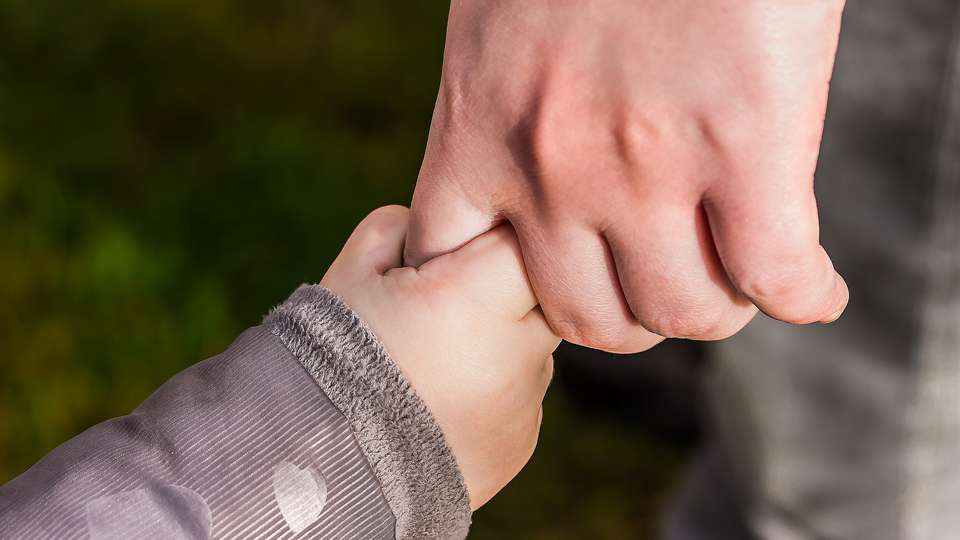 Ett barns hand i en vuxen hand.