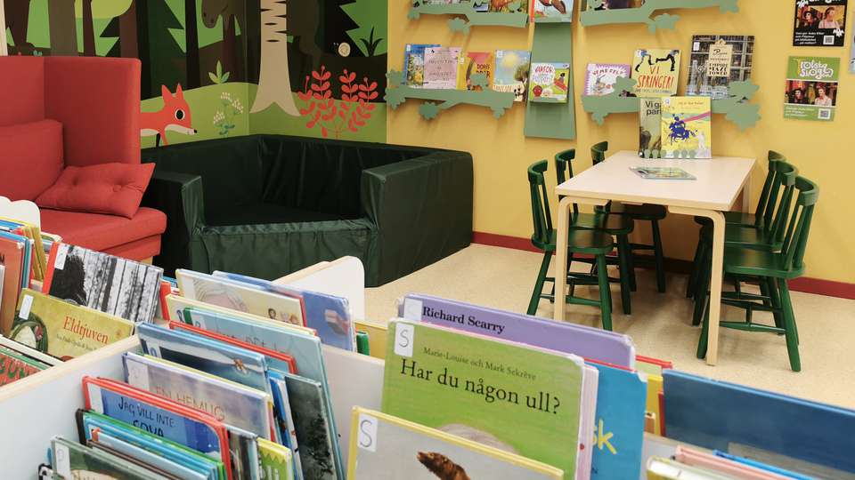 böcker, bord och stolar i bibliotekets barnhörna