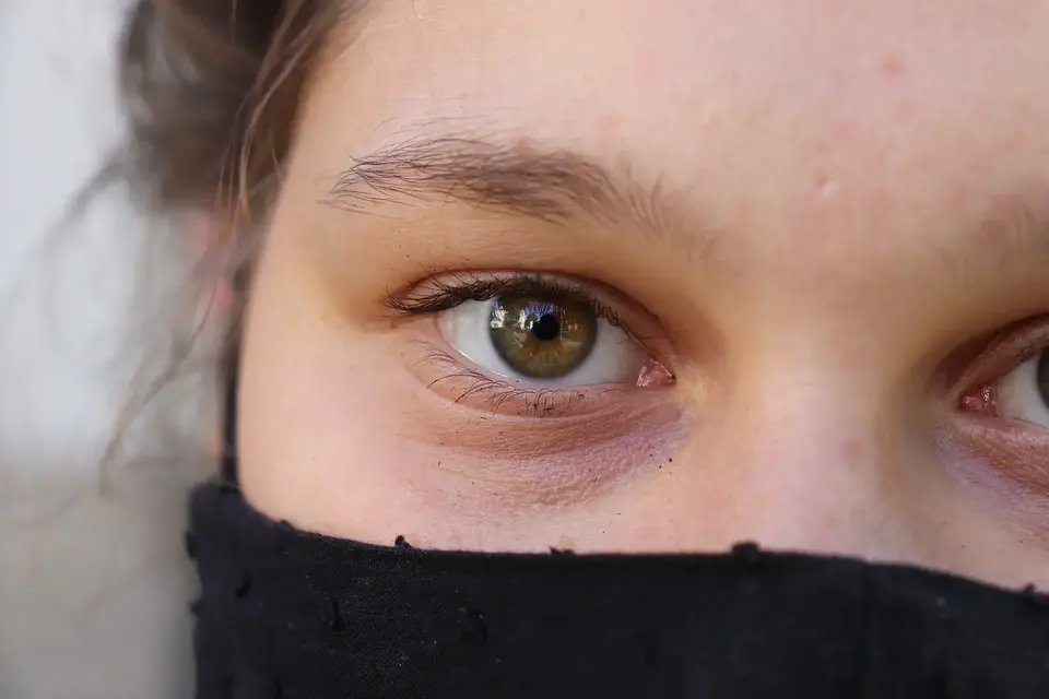 Närbild av en kvinnas ansikte med munskydd.